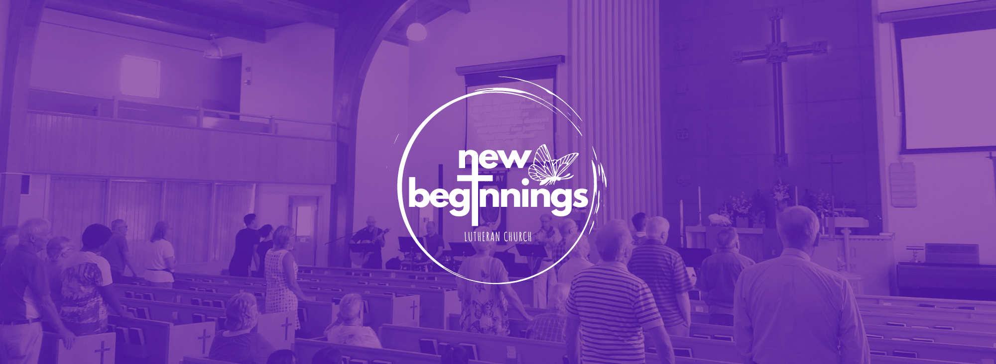 Photo of the congregation singing inside the church building with New Beginnings logo in front