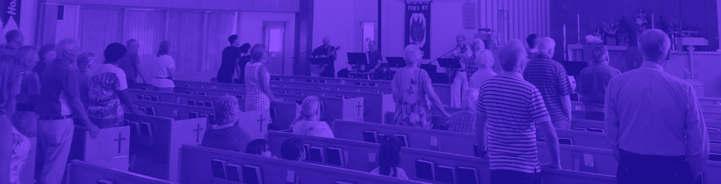 People inside the church standing and worshipping