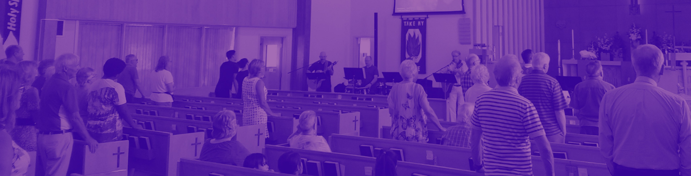 People inside the church standing and worshipping